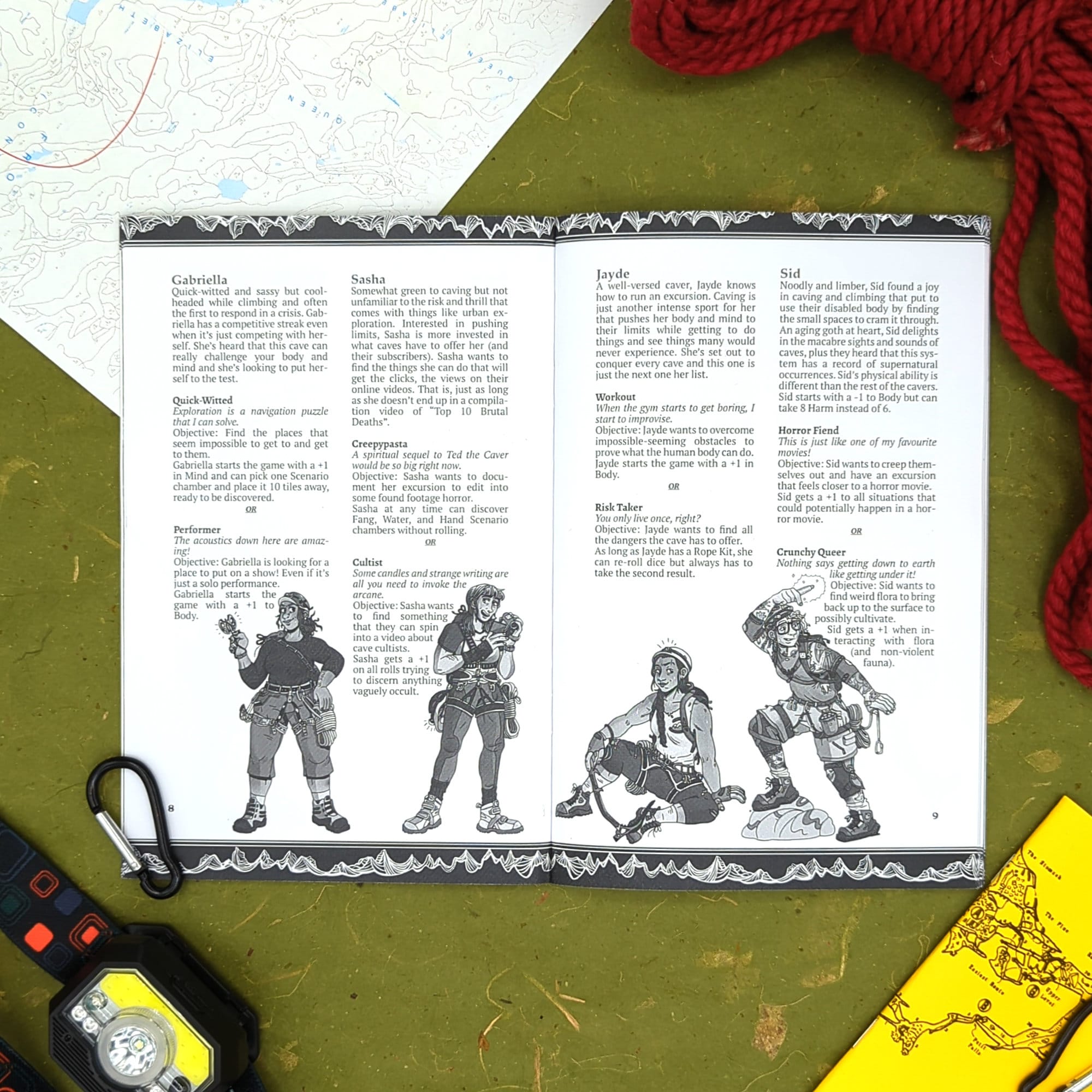 A photograph of the interior of Underneath, showing four of the cavers that you can be while exploring the cave system. There's Gabriella, Sasha, Jayde, and Sid, and each have on caving gear like harnesses, helmets, headlamps, hiking shoes, and more.