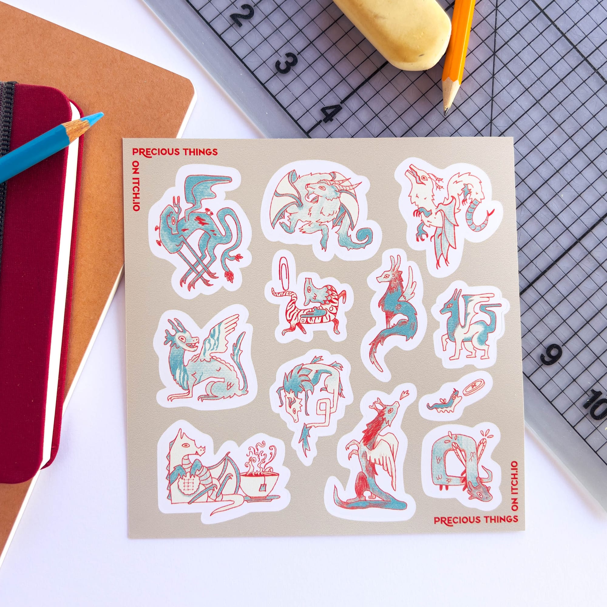 A Photo of the sticker sheet for Precious Things that has 12 small dragons on it in blue and red.