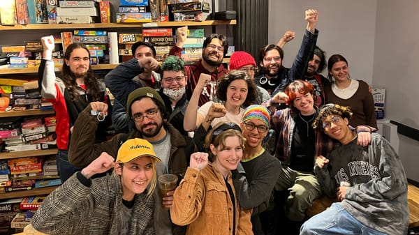 Fifteen Hex&Co workers with fists in the air after winning their union election vote.