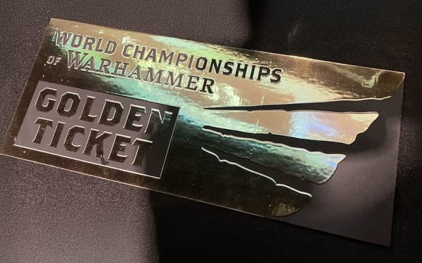 A photo of an embossed golden ticket with the words "World Championships of Warhammer" and "Golden Ticket.