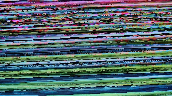 multicolor static from an old CRTV, reds fading into blues and greens